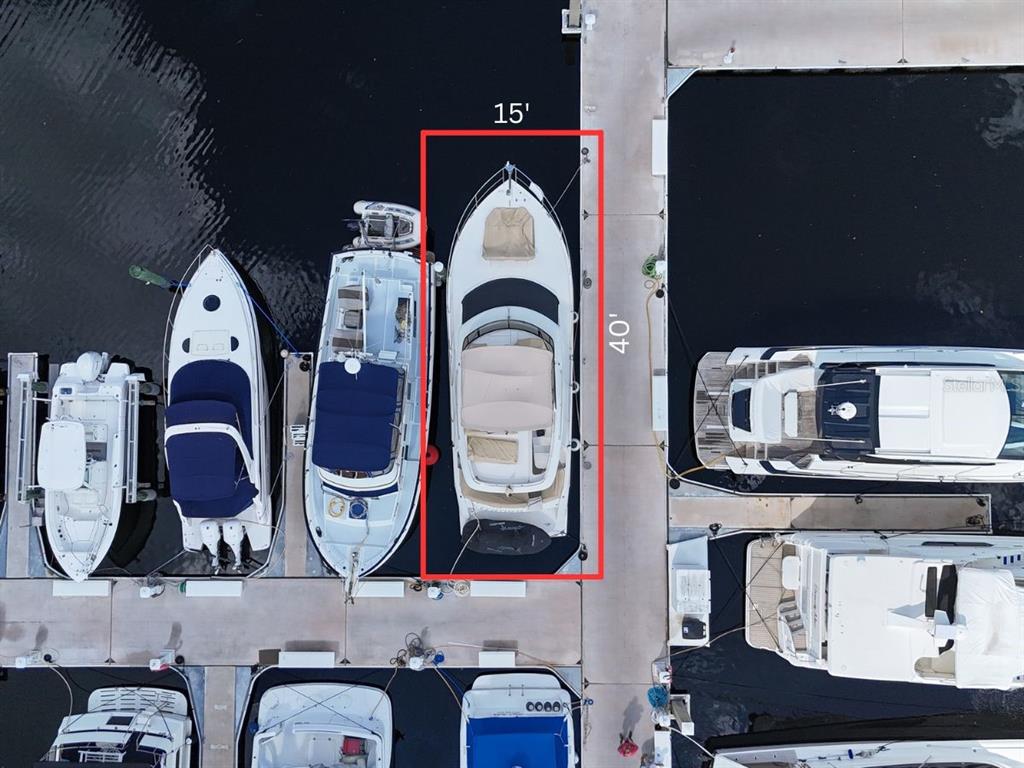 An aerial view shows a boat docked in a slip measuring 15 feet by 40 feet — 102 RIVIERA DUNES WAY UNIT S-97, PALMETTO, FL