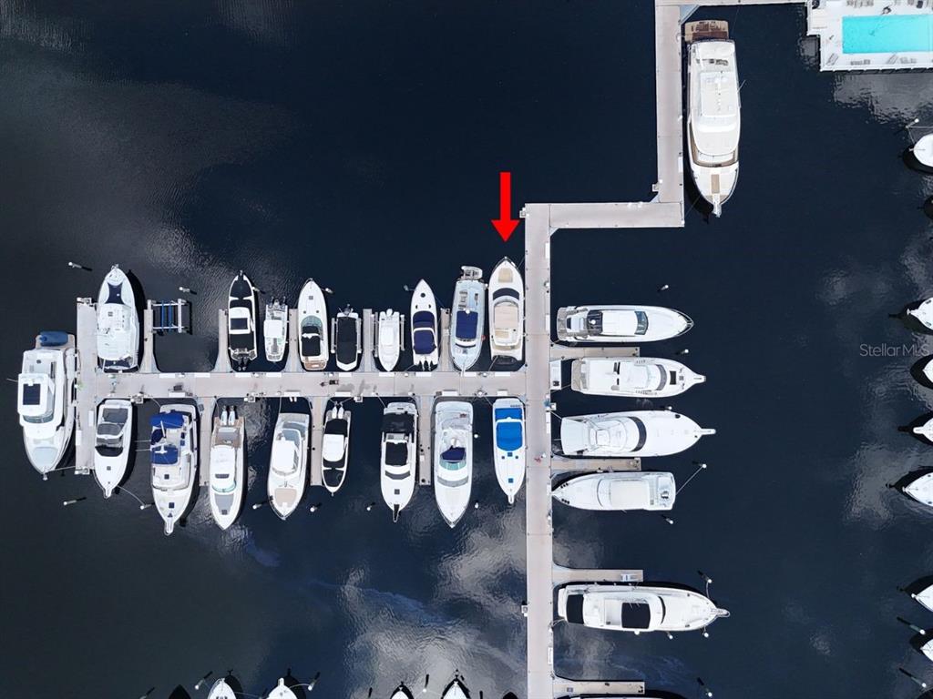 This aerial view shows a marina with multiple boats docked along concrete piers — 102 RIVIERA DUNES WAY UNIT S-97, PALMETTO, FL