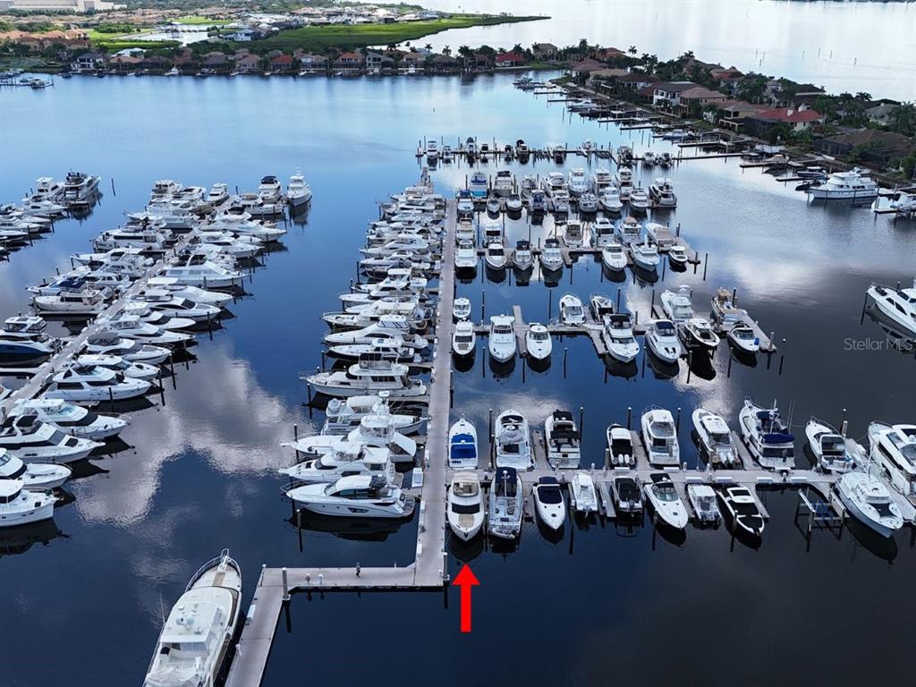 An aerial view shows a large marina filled with numerous boats docked along wooden piers — 102 RIVIERA DUNES WAY UNIT S-97, PALMETTO, FL