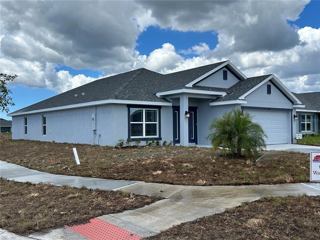 A single-story house with a gray stucco exterior, a shingled roof, and a two-car garage — 2655 AVERLAND LOOP, NORTH PORT, FL