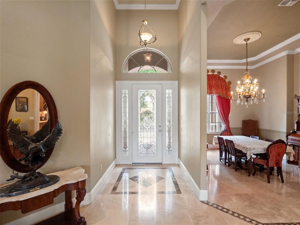 An entryway with tile flooring, a decorative front door, and a view into a dining room — 9223 HIDDEN BAY LANE, ORLANDO, FL
