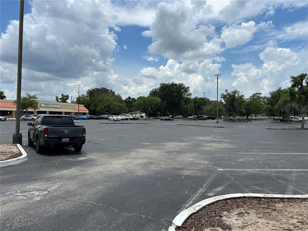 A large, paved parking lot with a pickup truck parked in the foreground — 1601 NE 25TH AVENUE UNIT 403, OCALA, FL