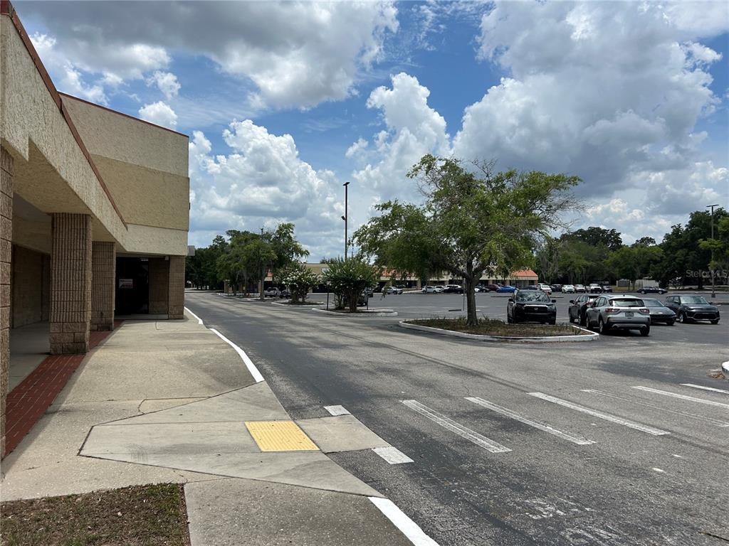 A view of a commercial building exterior with a sidewalk and a parking lot — 1601 NE 25TH AVENUE UNIT 403, OCALA, FL