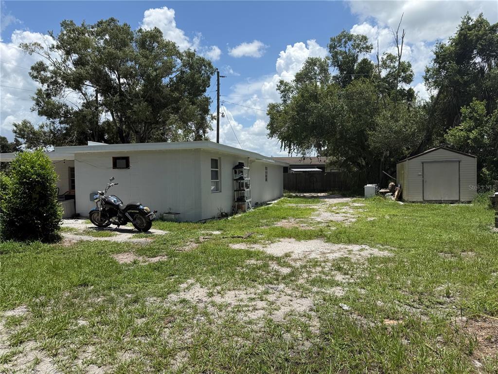 A white house with a motorcycle parked outside and a detached shed in the yard — 408 E MAPLE STREET, ARCADIA, FL