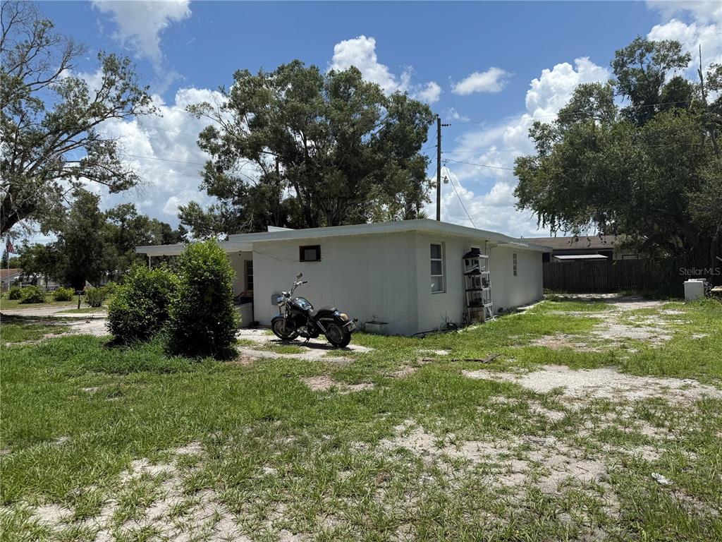 A white, single-story house with a motorcycle parked on a dirt and grass lot — 408 E MAPLE STREET, ARCADIA, FL