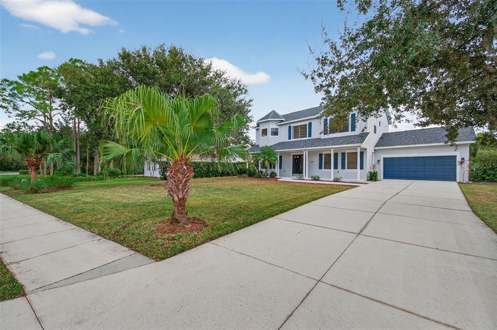 A two-story house with a blue garage door, white siding, and a palm tree in front — 3870 155TH AVENUE E, PARRISH, FL