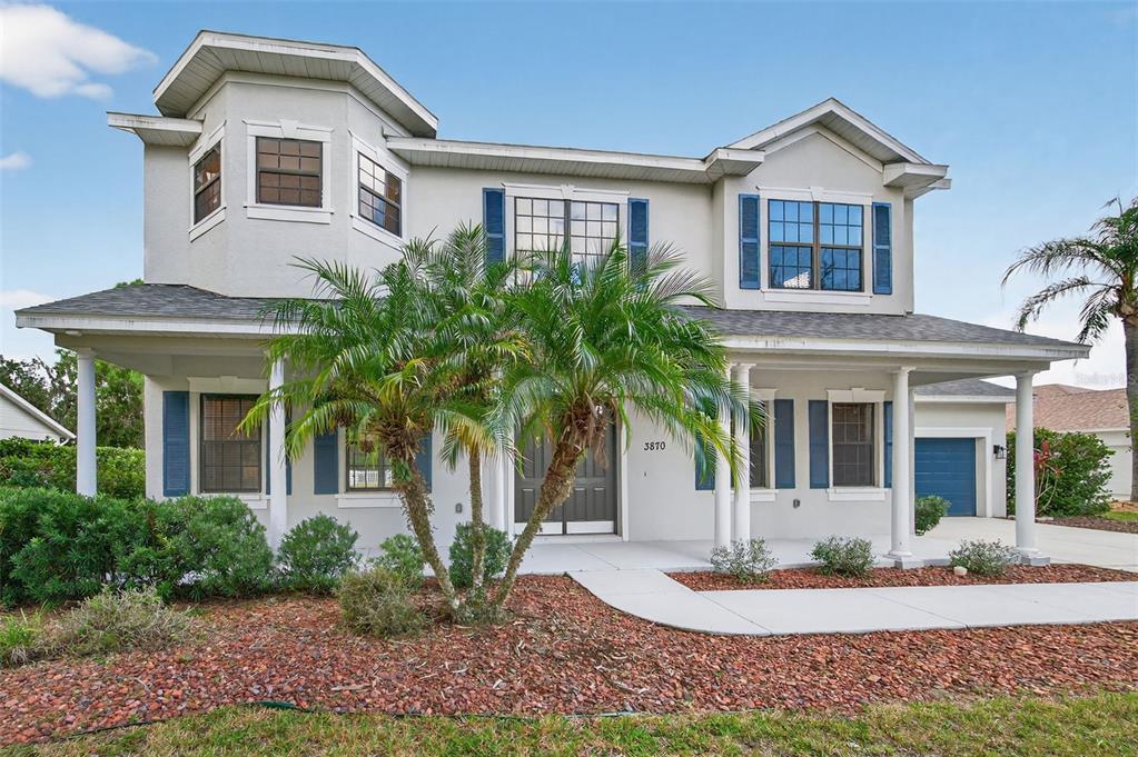 A two-story house with a covered front porch, blue shutters, and a palm tree — 3870 155TH AVENUE E, PARRISH, FL