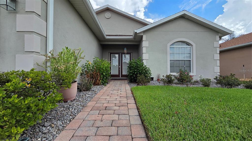 A paved walkway leads to the double front doors of a single-story suburban home — 4063 BIRKDALE DRIVE, LAKE WALES, FL