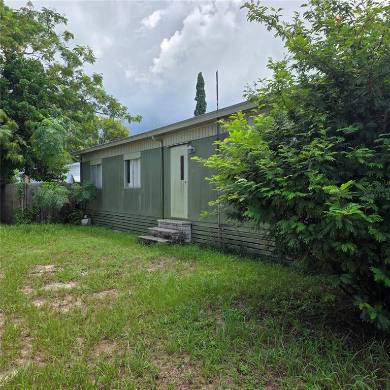 A single-story mobile home with green siding and a small set of concrete steps — 4122 CARDOON DRIVE, NEW PORT RICHEY, FL