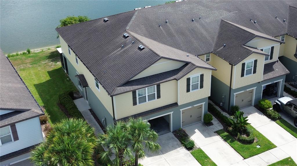 An aerial view shows a two-story townhouse with a garage next to a lake — 9154 HILLCROFT DRIVE, RIVERVIEW, FL