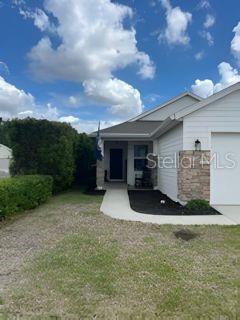A view of a house exterior featuring a stone-accented wall, a walkway, and landscaping — 8083 GUILD WAY, JACKSONVILLE, FL
