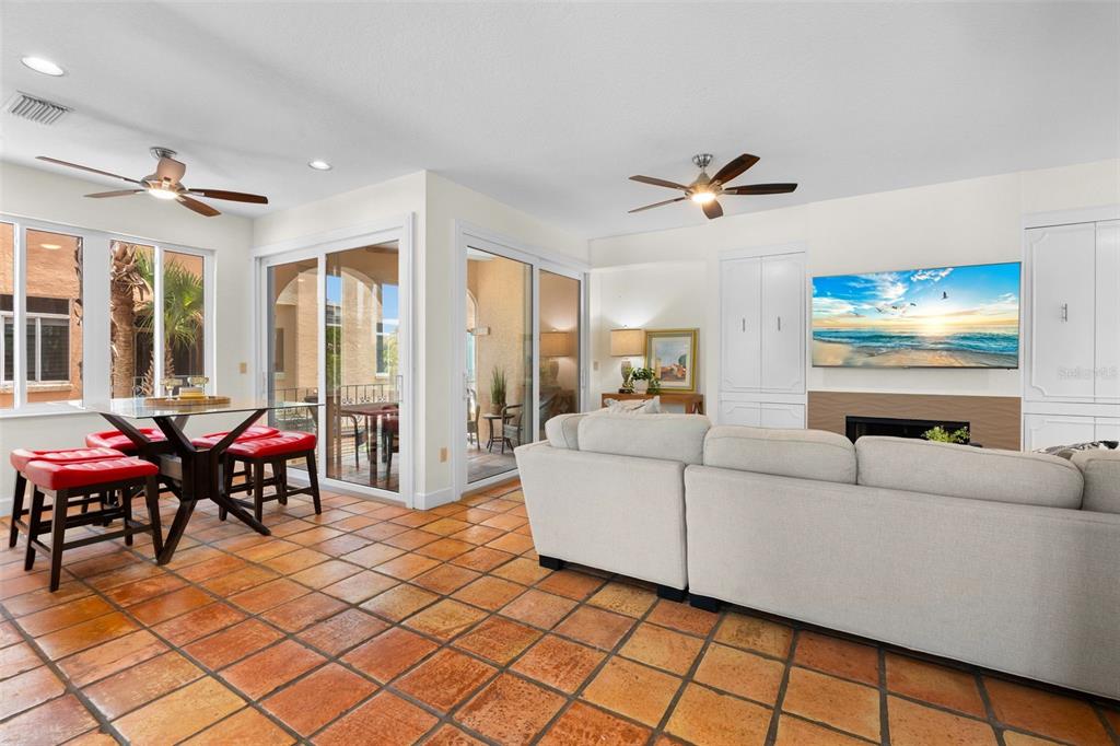 A living room and dining area with terracotta tile floors, a sectional sofa, and fireplace — 306 BEACH ROAD UNIT 306, SARASOTA, FL