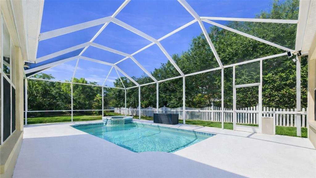 A swimming pool and spa are enclosed within a white screened-in patio area — 3209 PARTRIDGE POINT TRAIL, VALRICO, FL