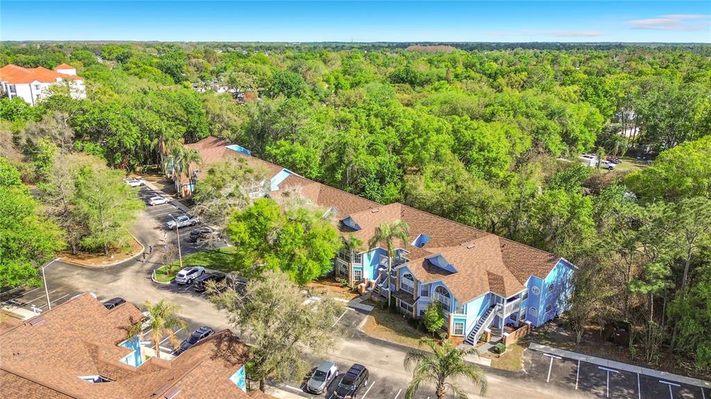 An aerial view shows a multi-story apartment building with a brown roof and blue siding — 2717 N POINCIANA BOULEVARD UNIT 176, KISSIMMEE, FL