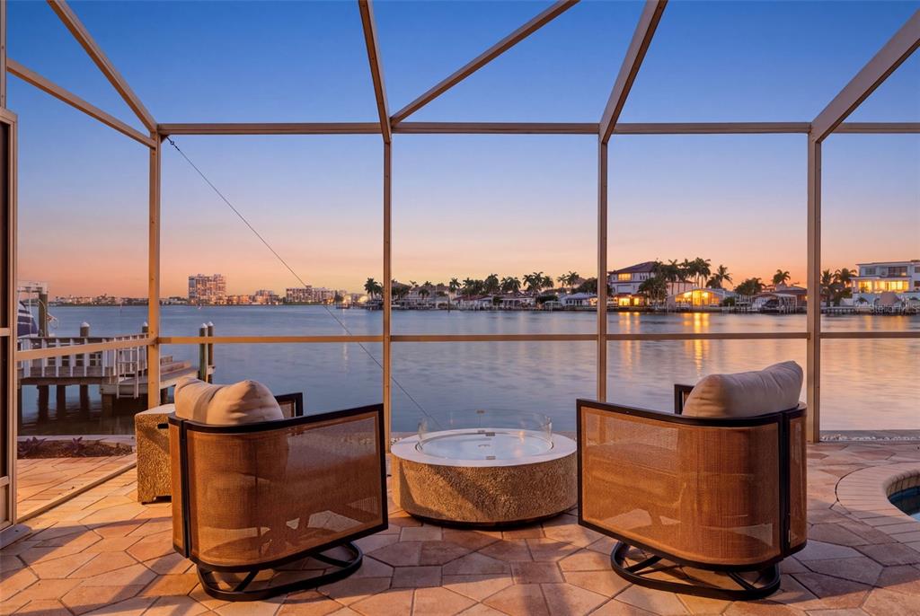 A living room with light wood floors, leather sofas, and a view of the water — 661 79TH CIRCLE S, ST PETERSBURG, FL
