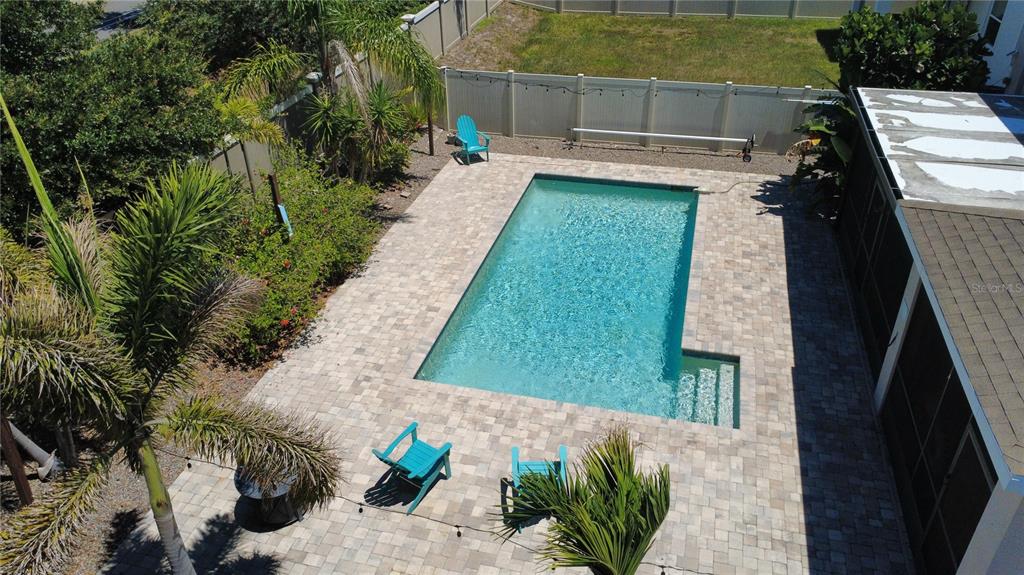 An aerial view of a rectangular swimming pool with a paver patio and lounge chairs — 5002 JACKEL CHASE DRIVE, WIMAUMA, FL
