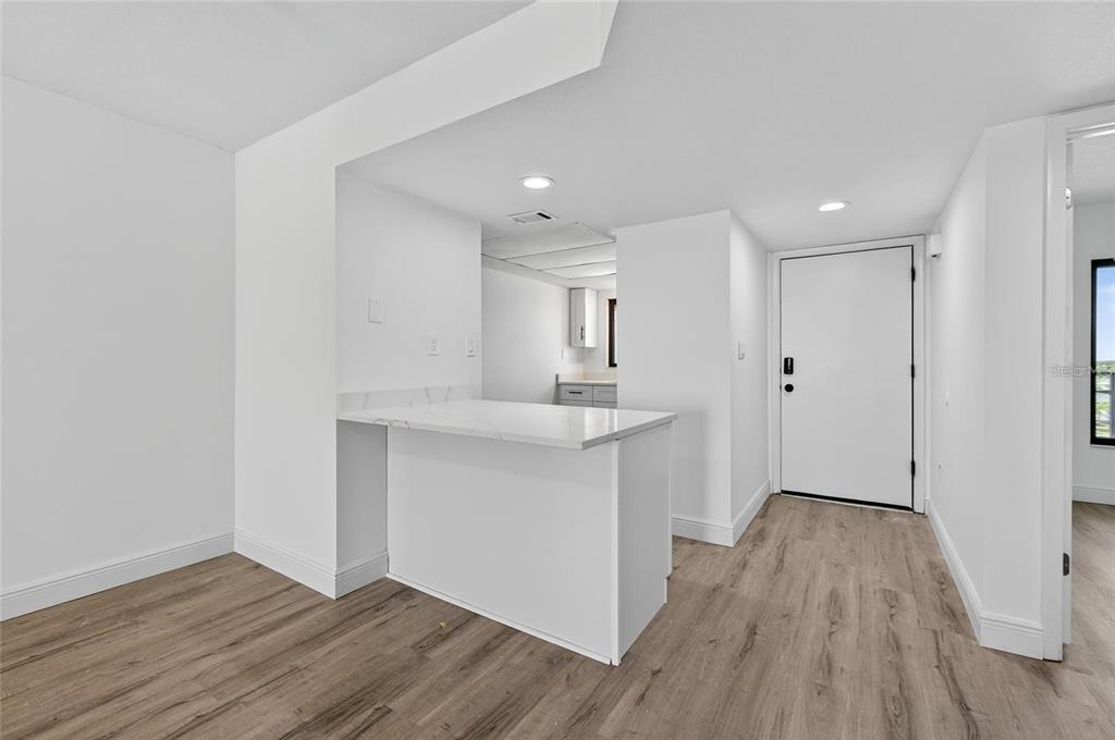 A bright room features a white kitchen island with a countertop and wood-look flooring — 1275 OCEAN SHORE BOULEVARD UNIT P3, ORMOND BEACH, FL