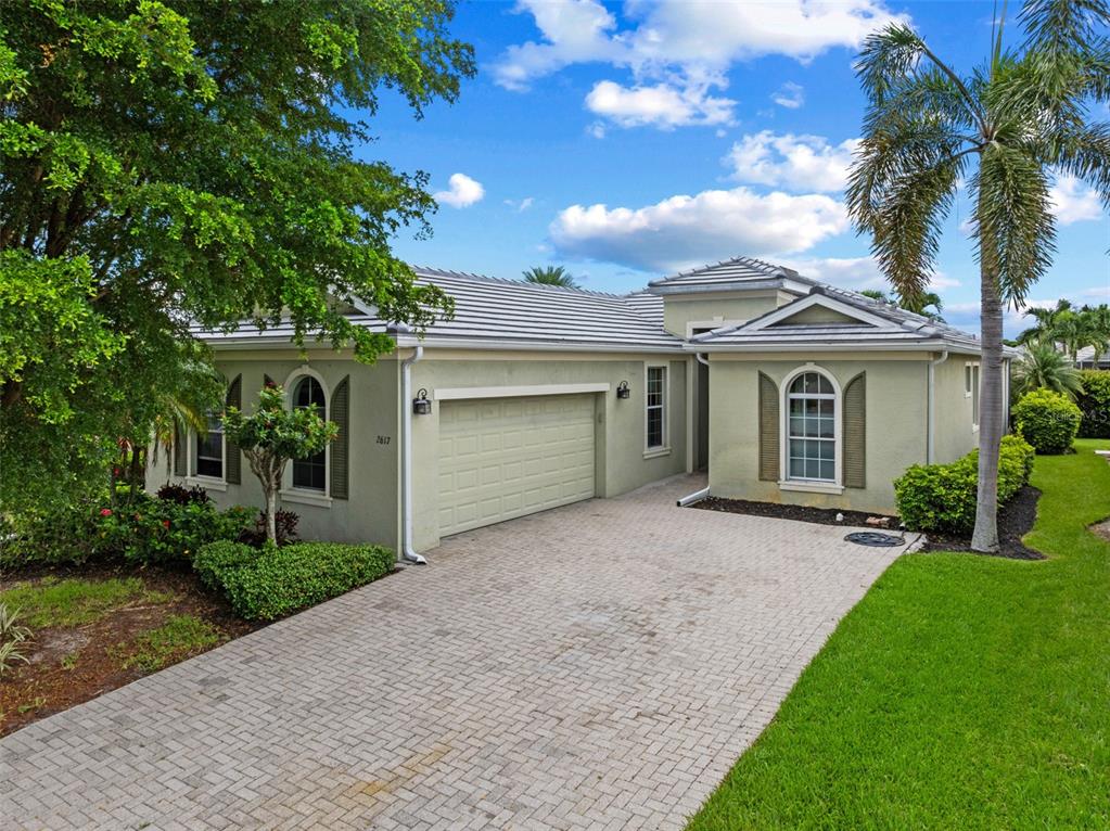 A single-story house with a light green exterior, a paved driveway, and a two-car garage — 2617 BRIGHTSIDE COURT, CAPE CORAL, FL