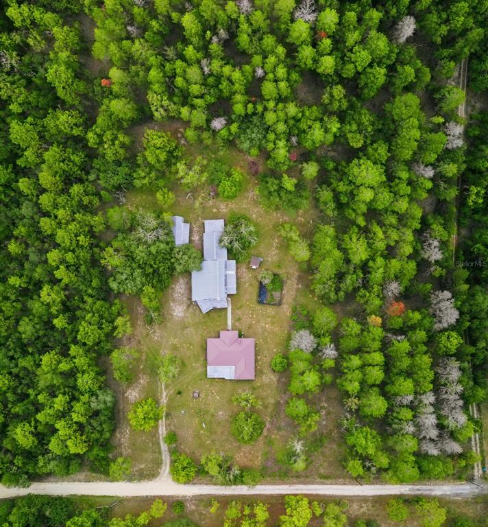 An aerial view shows a house and a detached building surrounded by a wooded lot — 14499 SANDY DRIVE, BROOKSVILLE, FL