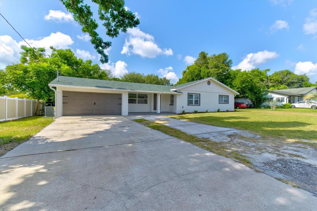 A single-story house with a green roof, white exterior, and a concrete driveway — 47 DAHLIA DRIVE, DEBARY, FL