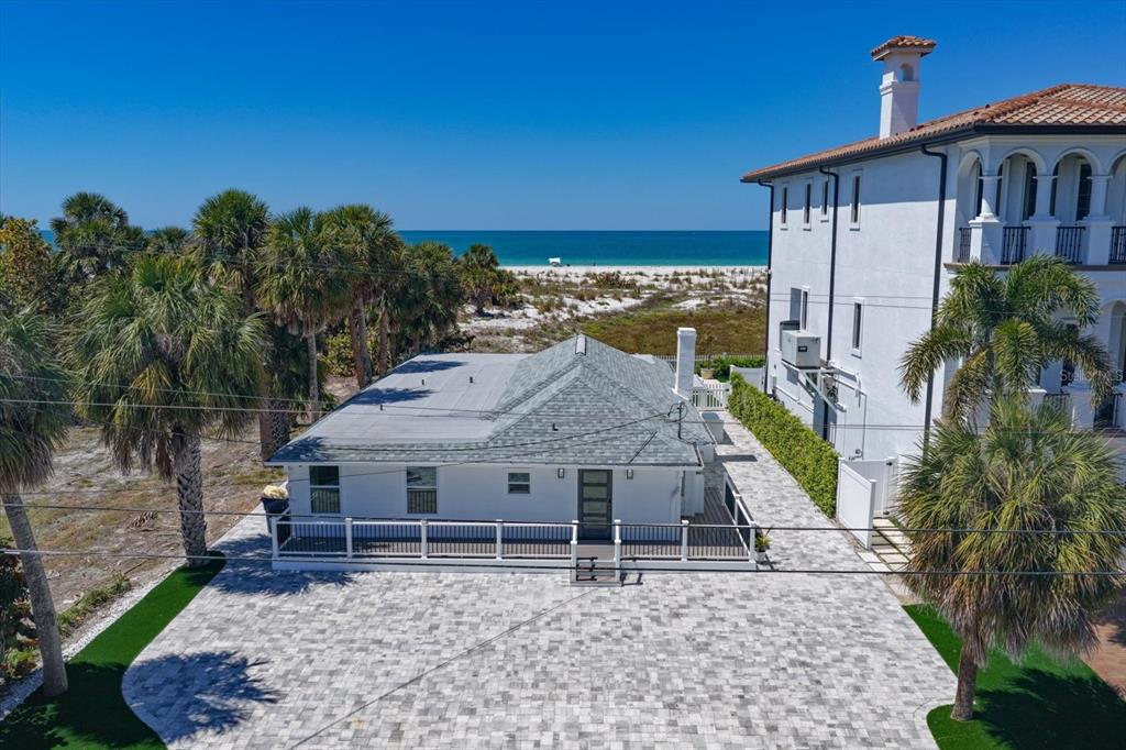An aerial view shows a white house with a gray roof next to a larger building — 1038 ELDORADO AVENUE, CLEARWATER, FL
