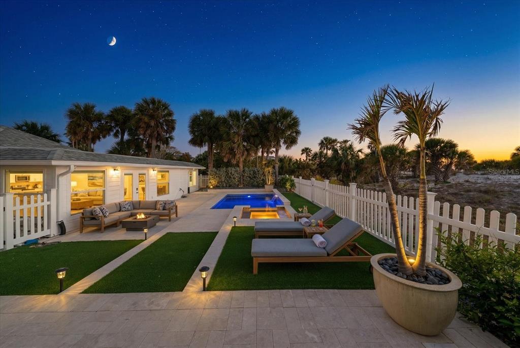 A backyard patio features a swimming pool, hot tub, lounge chairs, and artificial turf — 1038 ELDORADO AVENUE, CLEARWATER, FL