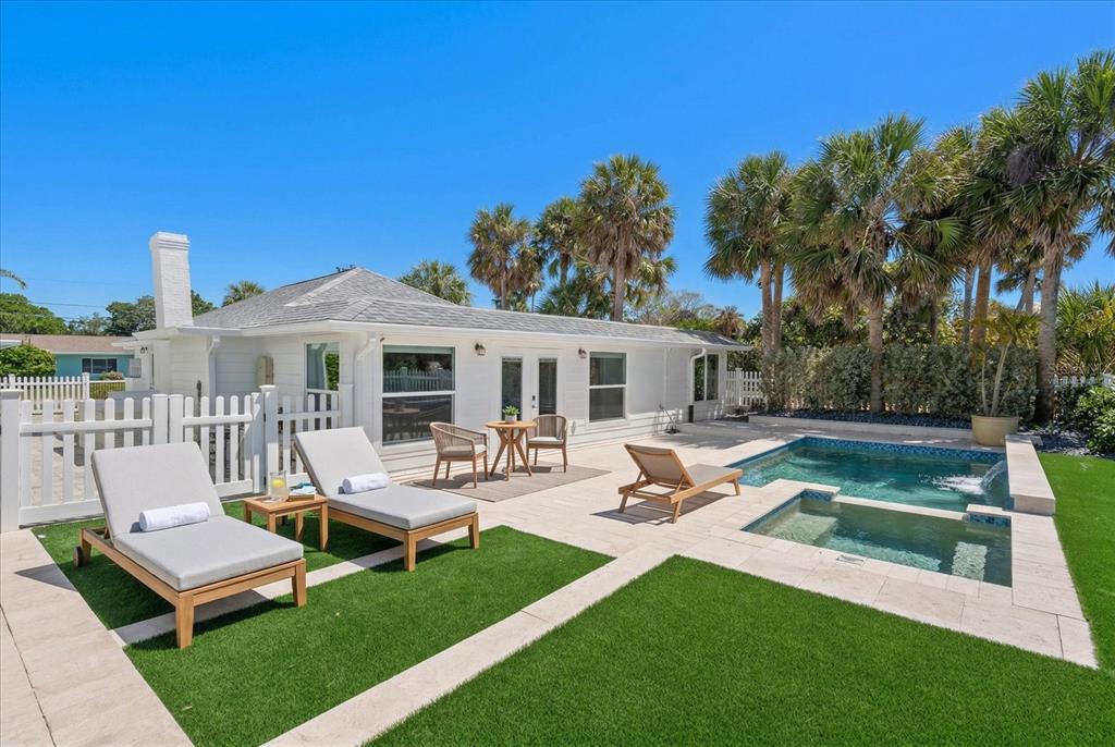 A white house with a pool, hot tub, and lounge chairs on a patio — 1038 ELDORADO AVENUE, CLEARWATER, FL