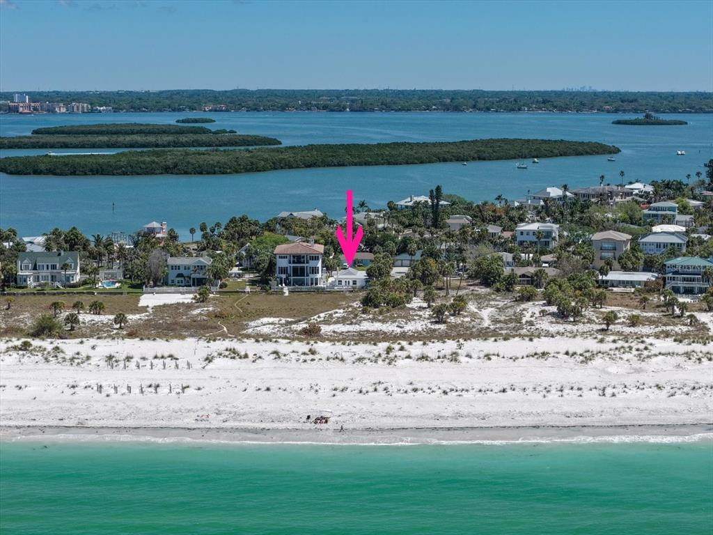 An aerial view shows a beach house with a pink arrow pointing toward it — 1038 ELDORADO AVENUE, CLEARWATER, FL