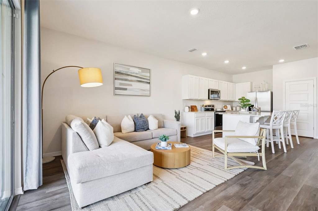 A living room with a sectional sofa, coffee table, and an open kitchen with island — 2765 GLADIOLA ROAD, WINTER HAVEN, FL