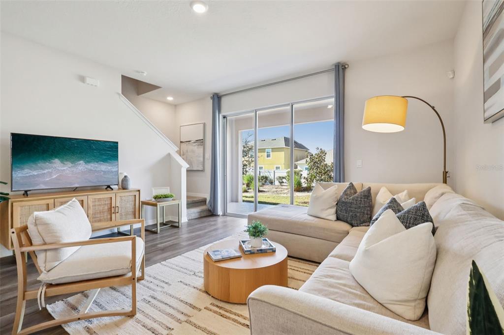 A living room features a sectional sofa, an armchair, a coffee table, and sliding glass doors — 2765 GLADIOLA ROAD, WINTER HAVEN, FL