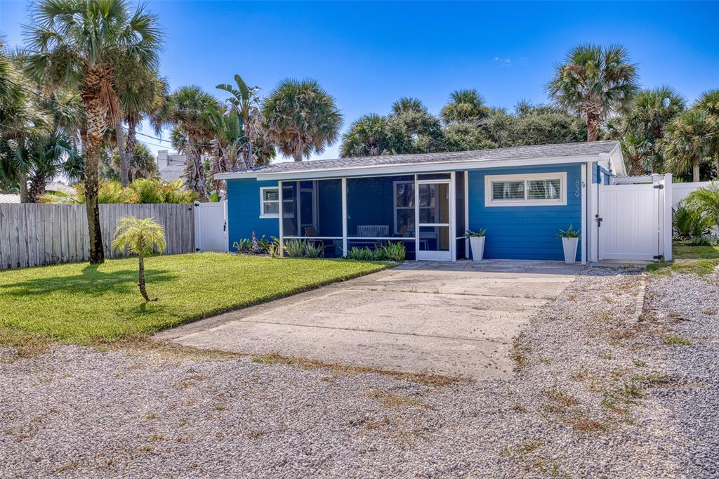 An aerial view shows a coastal neighborhood with houses, palm trees, and the ocean beyond — 839 E 10TH AVENUE, NEW SMYRNA BEACH, FL