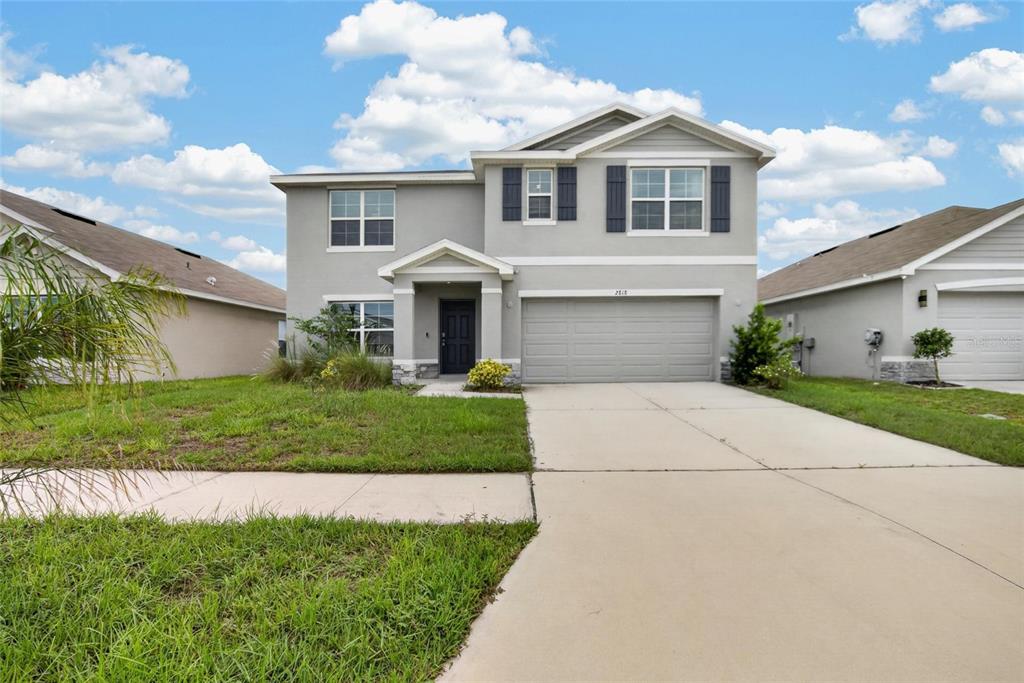 A two-story gray house with a two-car garage and a concrete driveway — 2818 GUMBO LIMBO DRIVE, WIMAUMA, FL