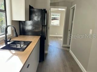 A kitchen features light wood countertops, a black refrigerator, and a black faucet — 3000 CLARCONA ROAD UNIT 823, APOPKA, FL