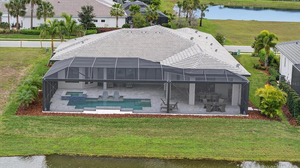 A modern single-story house features a stone facade, gray siding, and a paved driveway — 4034 BUTTE TRAIL, BRADENTON, FL