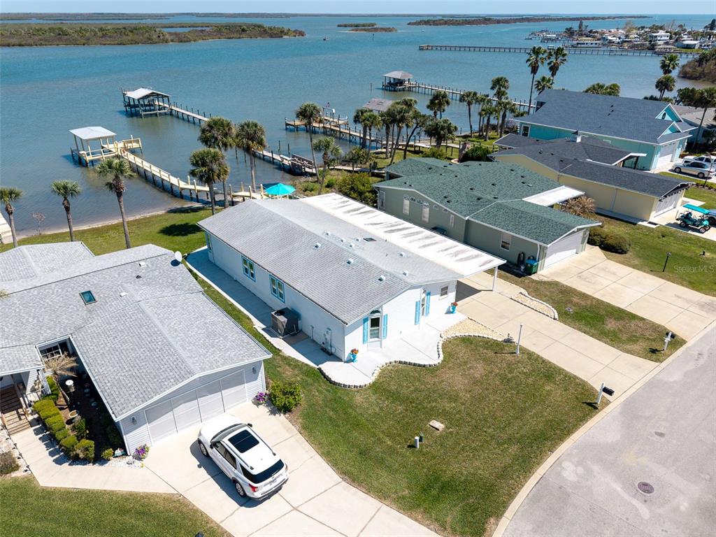 An aerial view shows waterfront homes with private docks, driveways, and palm trees — 349 MARSH LANDING LOOP, OAK HILL, FL