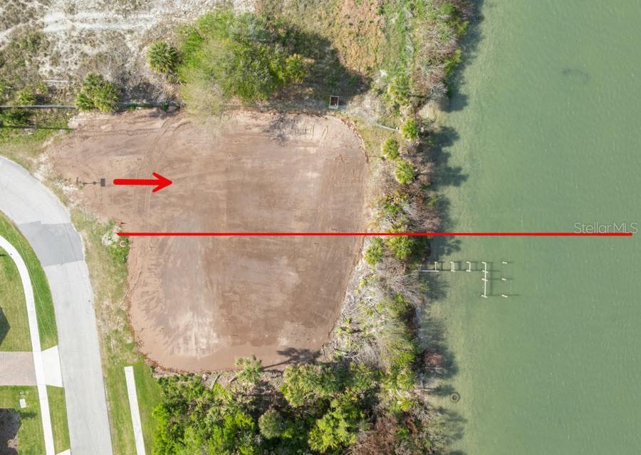 An aerial view shows a cleared, vacant waterfront lot with a small wooden dock — 183 JONES FISH CAMP ROAD, EDGEWATER, FL