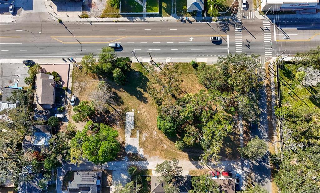 An aerial view shows a vacant, tree-lined lot with a concrete slab foundation — 1118 S DR MARTIN LUTHER KING JR STREET S, ST PETERSBURG, FL