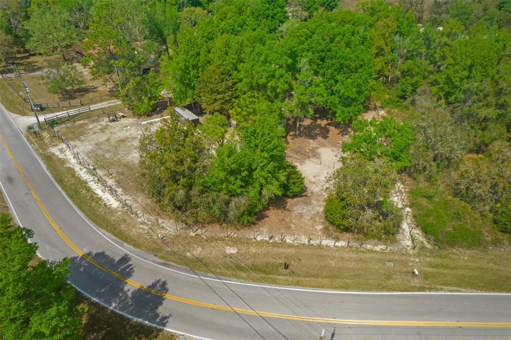An aerial view shows a partially cleared, wooded lot bordered by a paved road — 17755 BOSLEY, SPRING HILL, FL