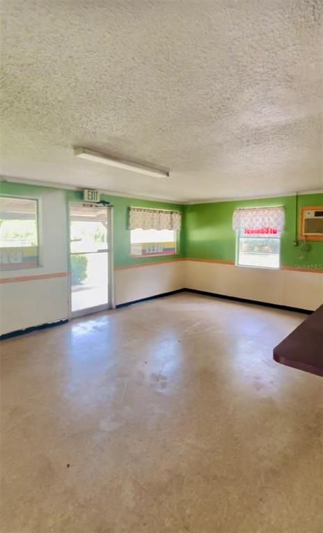 An interior view of a room with green walls, a textured ceiling, and a glass door — 7103 N CARL G ROSE HIGHWAY, HERNANDO, FL