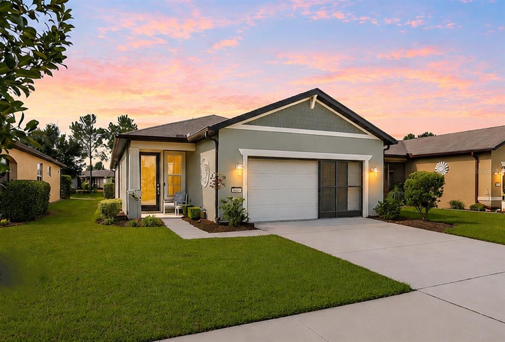 A single-story house with a green exterior, a two-car garage, and a concrete driveway — 9664 SW 63RD LOOP, OCALA, FL