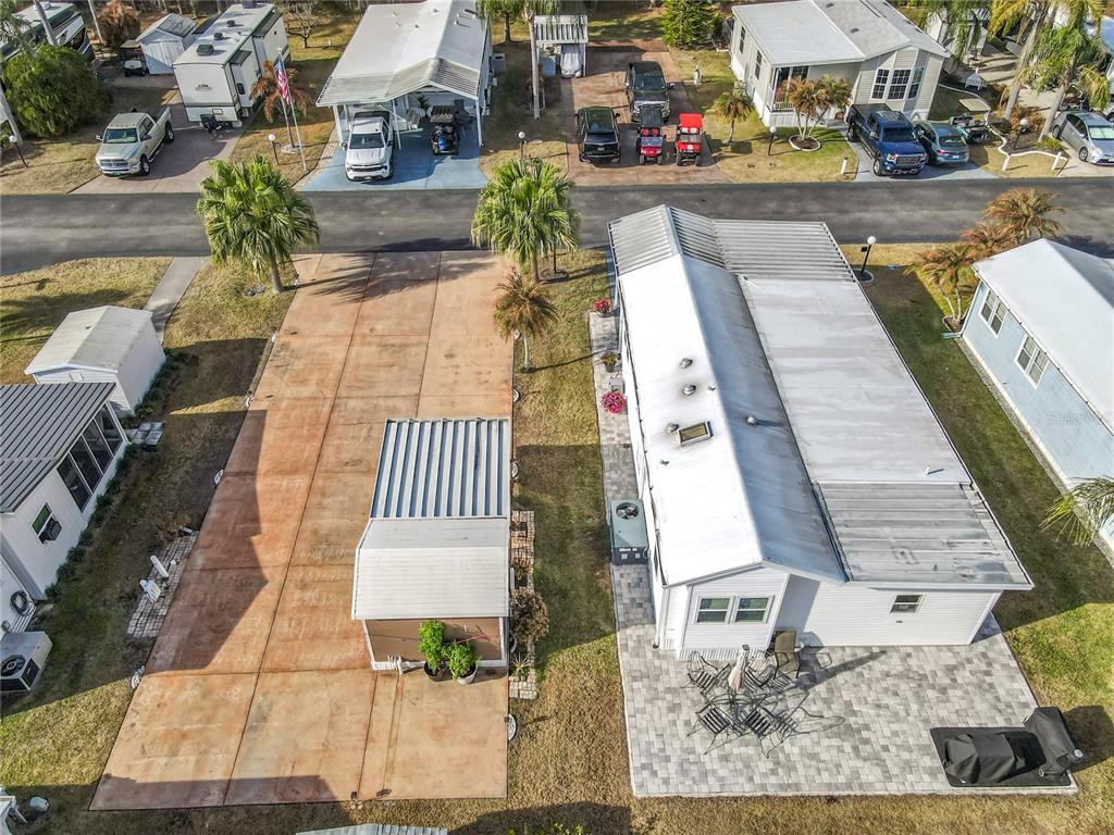 An aerial view shows a mobile home with a paved patio and an adjacent driveway — 450 PINE LOOP, FROSTPROOF, FL