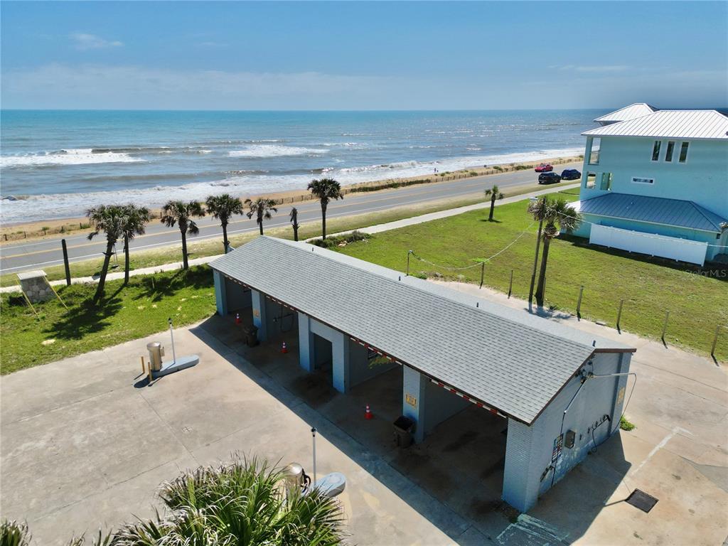 An aerial view shows a multi-bay car wash building located near a beach and road — 2299 N OCEANSHORE BOULEVARD, FLAGLER BEACH, FL