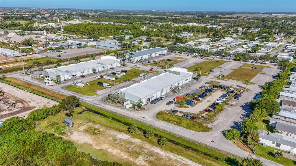 An aerial view shows two commercial warehouse buildings surrounded by parking lots and nearby residential areas — 6640 TAYLOR ROAD UNIT B, PUNTA GORDA, FL