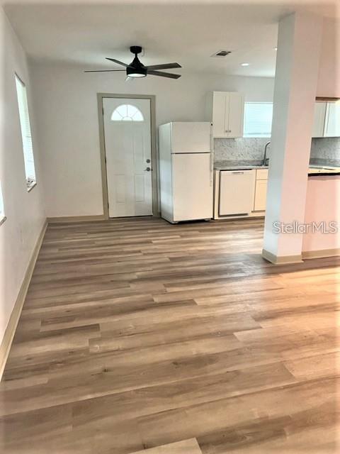A kitchen and dining area feature light wood-look flooring, a ceiling fan, and white appliances — 2185 FLORENCE ROAD, MOUNT DORA, FL