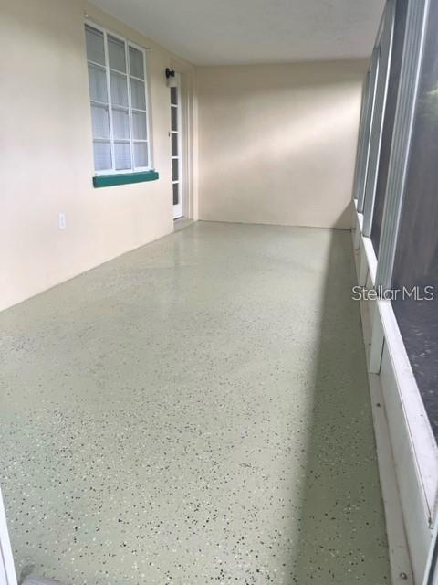 A screened-in porch with a light green speckled floor and a white door — 2185 FLORENCE ROAD, MOUNT DORA, FL