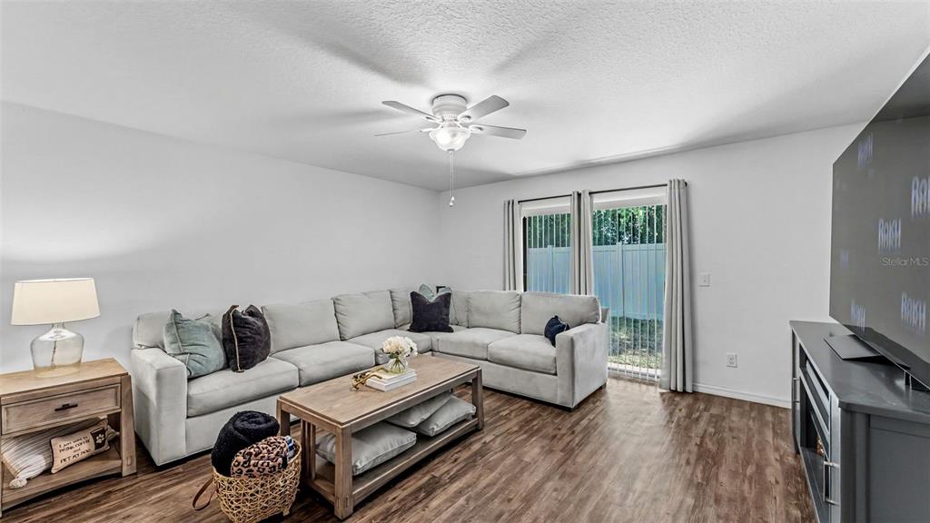 A living room features a light gray sectional sofa, a wooden coffee table, and wood flooring — 6270 MANITOBA DRIVE, LAKELAND, FL