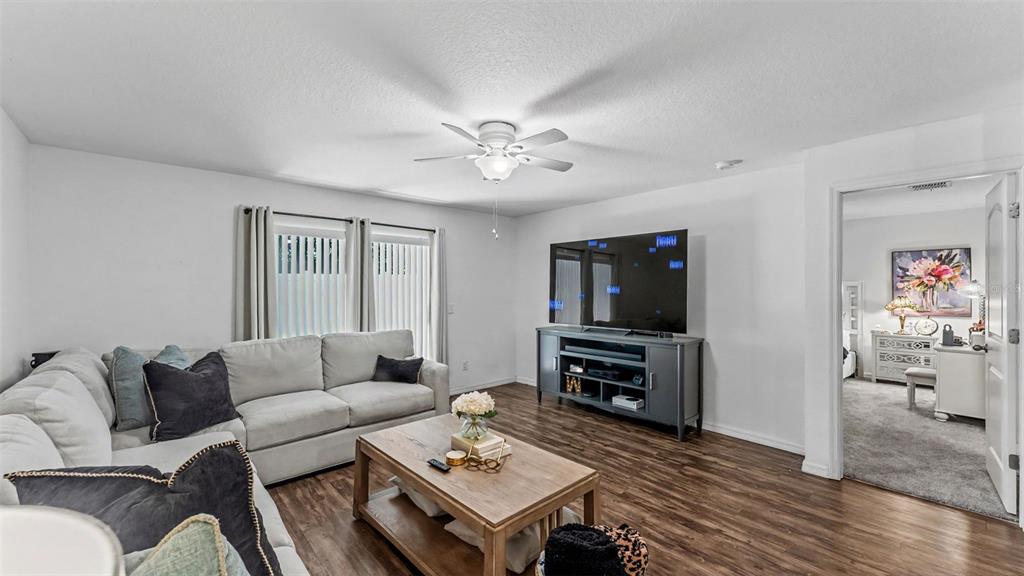 A living room features a sectional sofa, a wooden coffee table, and a television console — 6270 MANITOBA DRIVE, LAKELAND, FL