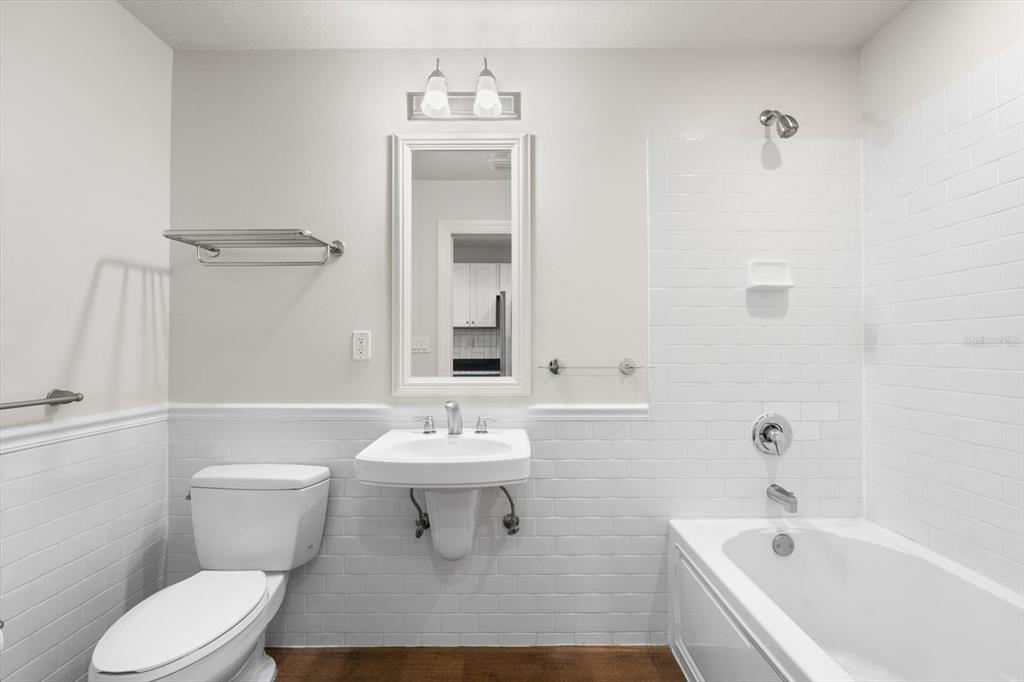 A bathroom features a wall-mounted sink, a toilet, and a bathtub with white subway tile — 536 BAHIA BEACH BOULEVARD UNIT 216B, RUSKIN, FL