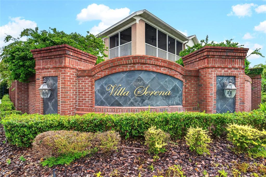A brick entrance sign for Villa Serena sits in front of a house with a screened porch — 2005 RIVER TURIA CIRCLE, RIVERVIEW, FL