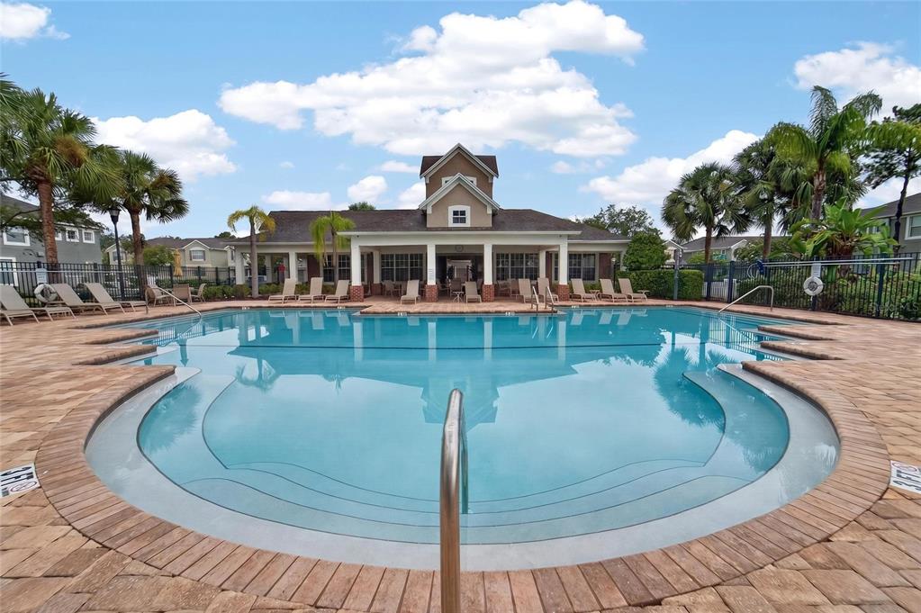 A swimming pool with a surrounding brick patio sits in front of a community clubhouse — 2005 RIVER TURIA CIRCLE, RIVERVIEW, FL
